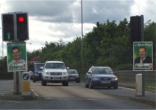 Cllrs. Padraig MacLochlainn and Pearse Doherty adorn the traffic lights in Omagh.