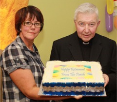 Fr Kevin O'Doherty receives his retirement celebration cake from organising committee member Rose Coyle.