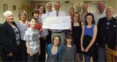 Brothers Leo and Denis McCauley, centre back, present a cheque for 1,100 to Moville Day Centre, proceeds of a charity bridge tournament in memory of their late mother Jane. Also pictured, from left, are Kathleen McDonald and Pauline McQuillan, Moville Bridge Club joint treasurers, Claire McGuinness, Moville Day Centre supervisor and Mary McCauley. Also pictured are Margaret Doherty, club secretary, John Gerard Doherty, club president, John McClenaghan, North West Bridge Association president and Neil McMahon, tournament director. Also included are Leo and Mary's children, James, Jane, Emma, Kate and Sarah. 