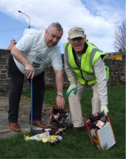 Cllr Mickey Doherty and John Putt of Moville Tidy Town committee pictured with some of the empty beer bottles picked up at the local children's playground.
